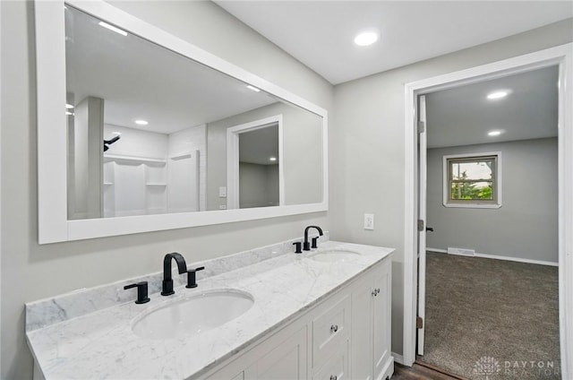 full bath with double vanity, a sink, visible vents, and recessed lighting