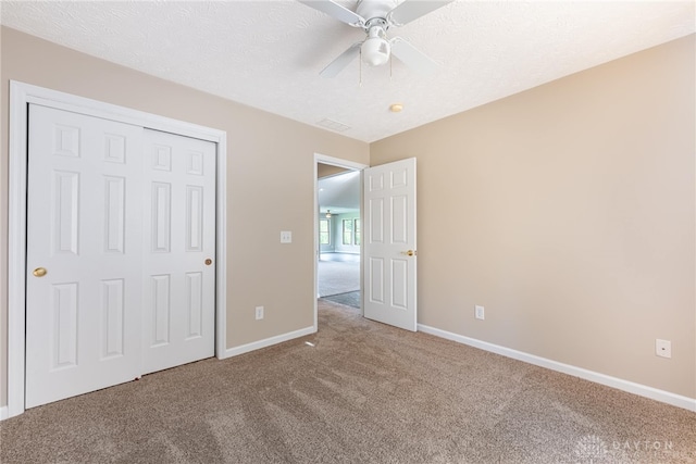 unfurnished bedroom with carpet floors, baseboards, ceiling fan, and a closet