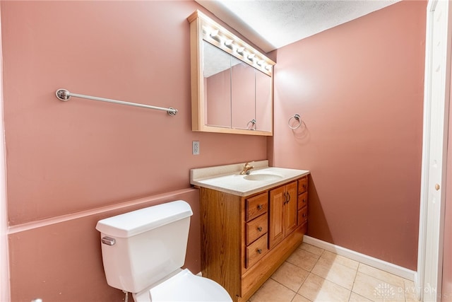 half bath with toilet, baseboards, tile patterned flooring, and vanity