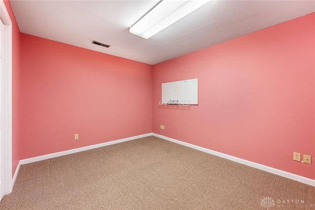 empty room with carpet flooring, baseboards, and visible vents