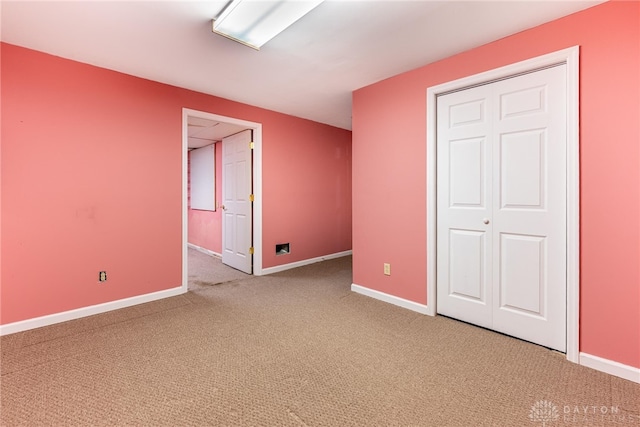 unfurnished bedroom featuring carpet floors, baseboards, and a closet