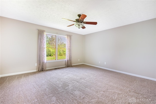 carpeted empty room featuring baseboards, a ceiling fan, and a textured ceiling
