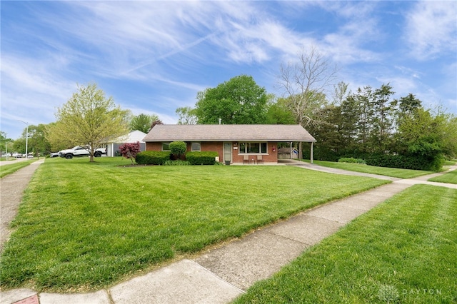 2661 Powhattan Pl, Dayton, OH 45420 - view of front of house with brick siding, an attached carport, a front yard, covered porch, and driveway