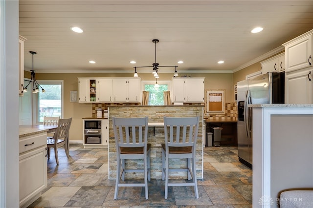 2661 Powhattan Pl, Dayton, OH 45420 - kitchen with decorative backsplash, built in microwave, a wealth of natural light, and stainless steel fridge with ice dispenser
