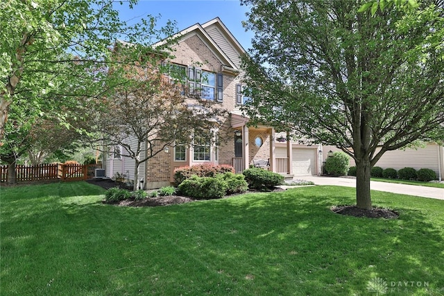 view of property hidden behind natural elements featuring brick siding, fence, a front yard, and concrete driveway