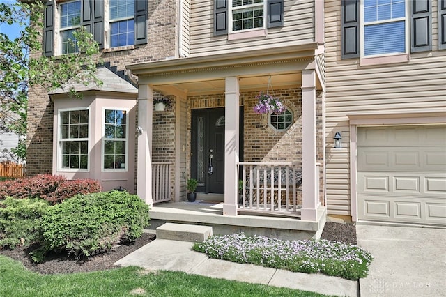 property entrance with brick siding, an attached garage, and covered porch