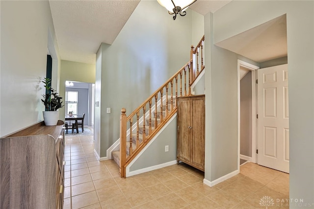 stairway featuring tile patterned flooring and baseboards