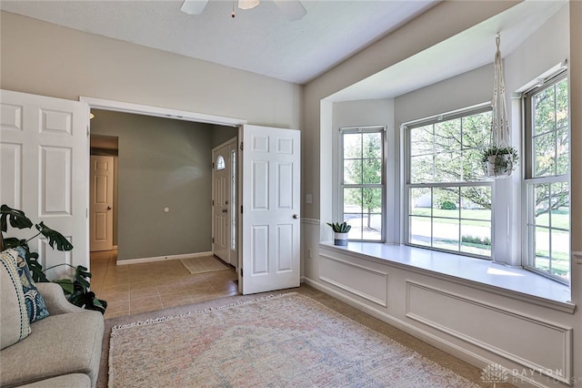interior space featuring a ceiling fan and baseboards