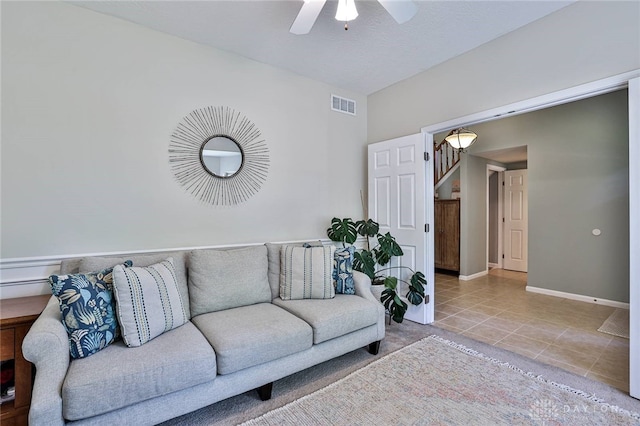 tiled living room with stairway, baseboards, a ceiling fan, and visible vents