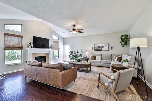living room with a textured ceiling, ceiling fan, vaulted ceiling, and a healthy amount of sunlight