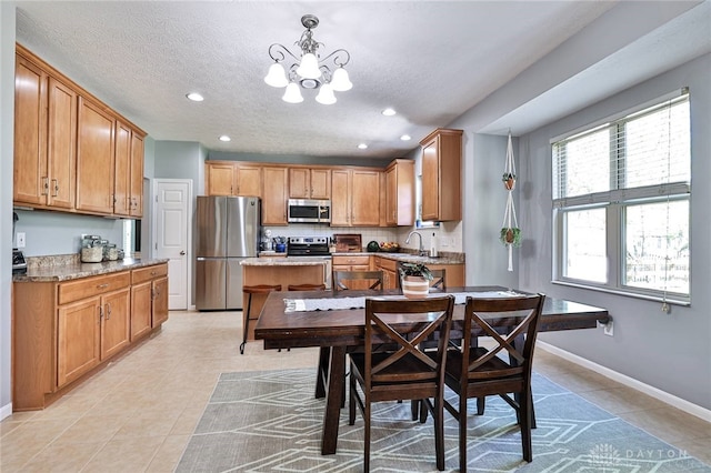 dining space with a textured ceiling, baseboards, a notable chandelier, recessed lighting, and light tile patterned flooring