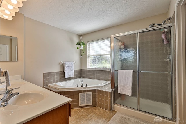 bathroom featuring visible vents, a garden tub, tile patterned flooring, a sink, and a stall shower