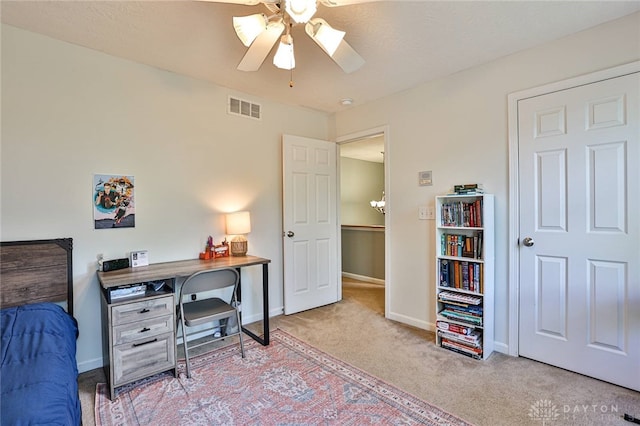 carpeted office space with ceiling fan, visible vents, and baseboards