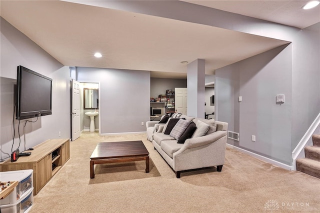 living area featuring recessed lighting, visible vents, stairs, and light colored carpet