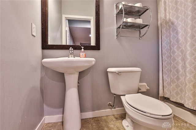 full bathroom featuring baseboards, tile patterned flooring, walk in shower, and toilet