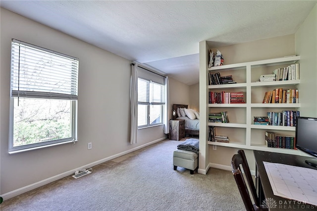 sitting room with carpet floors, baseboards, a textured ceiling, and visible vents