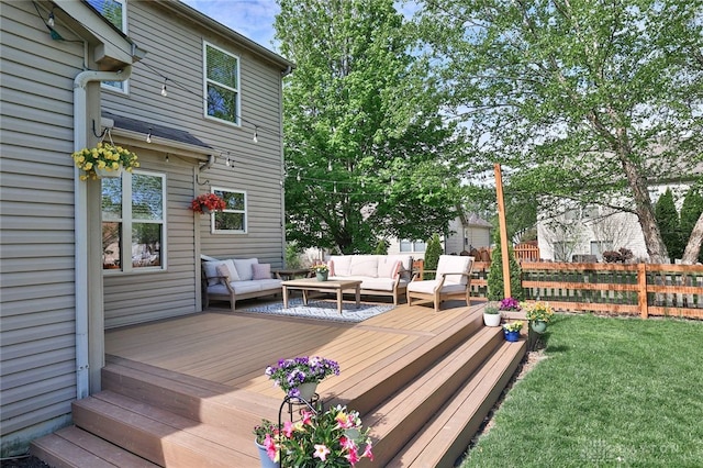 deck with outdoor lounge area, fence, and a yard