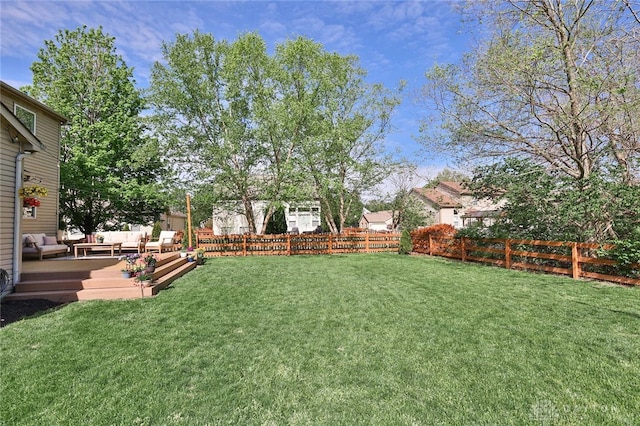 view of yard featuring a fenced backyard, a deck, and outdoor lounge area