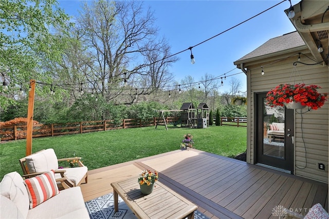 wooden deck featuring a fenced backyard, outdoor lounge area, a playground, and a yard