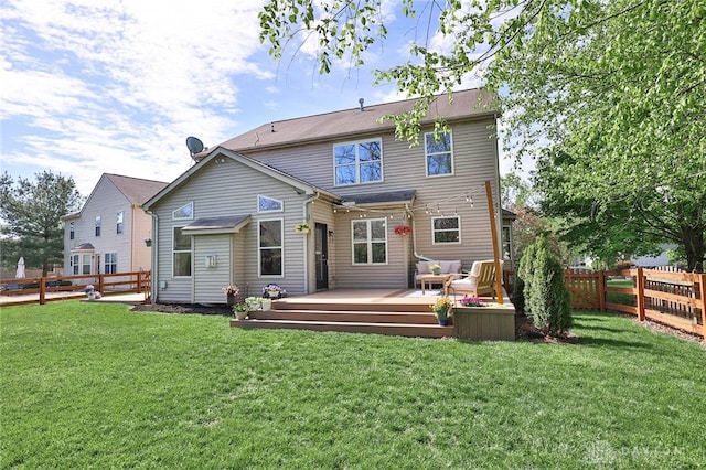 rear view of property with a lawn, a deck, a fenced backyard, and an outdoor hangout area