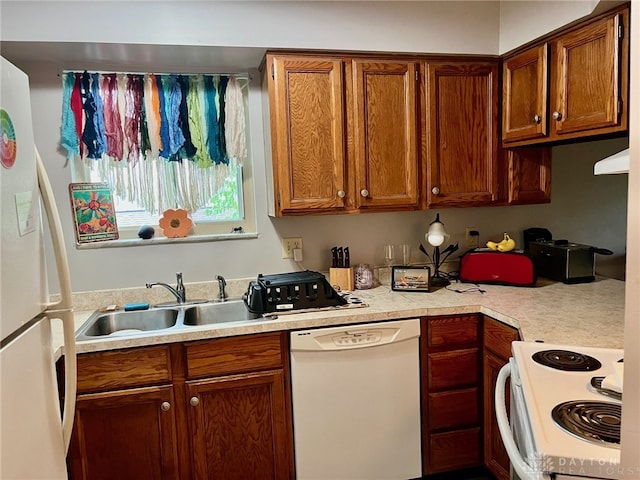 kitchen featuring white appliances, brown cabinets, a sink, and light countertops