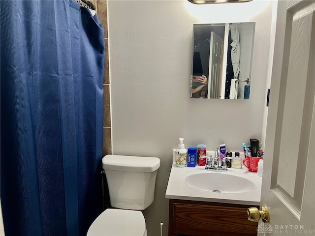 full bathroom featuring vanity, a shower with shower curtain, and toilet