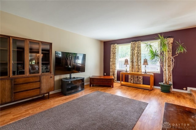 living area with baseboards and wood finished floors