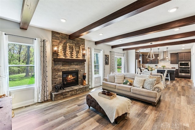 2187 Hamilton Rd, Lebanon, OH 45036 - living room with visible vents, beam ceiling, a fireplace, baseboards, and light wood-style flooring