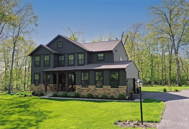 2187 Hamilton Rd, Lebanon, OH 45036 - craftsman house featuring covered porch, driveway, a front yard, an attached garage, and stone siding