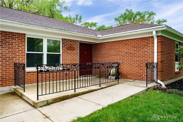 3600 Honeybrook Ave, Dayton, OH 45415 - doorway to property featuring roof with shingles, a patio, and brick siding