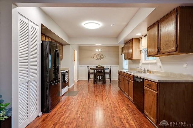 3600 Honeybrook Ave, Dayton, OH 45415 - kitchen featuring a sink, light countertops, wood finished floors, pendant lighting, and black appliances