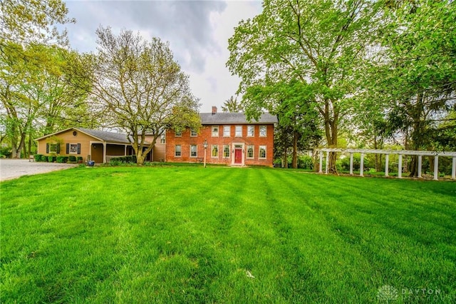 exterior space with a yard, a chimney, and a pergola