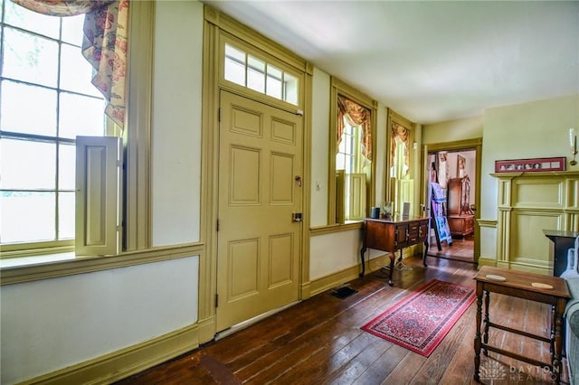 entrance foyer featuring dark wood finished floors and baseboards