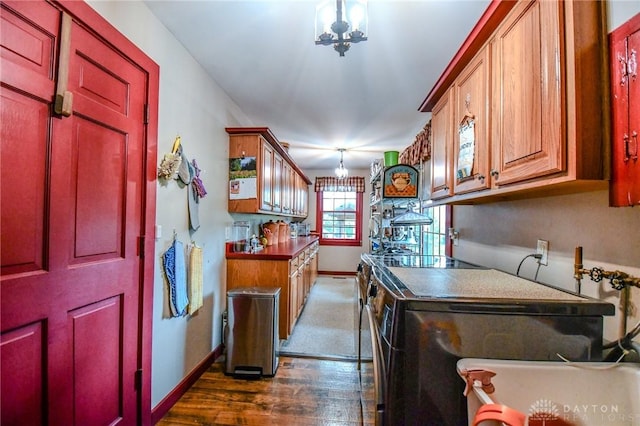 laundry room with an inviting chandelier, baseboards, dark wood-style floors, and washer and dryer