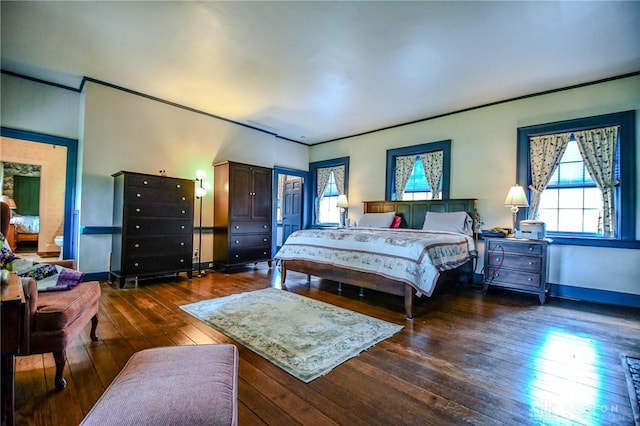 bedroom with baseboards, ornamental molding, and dark wood-style floors