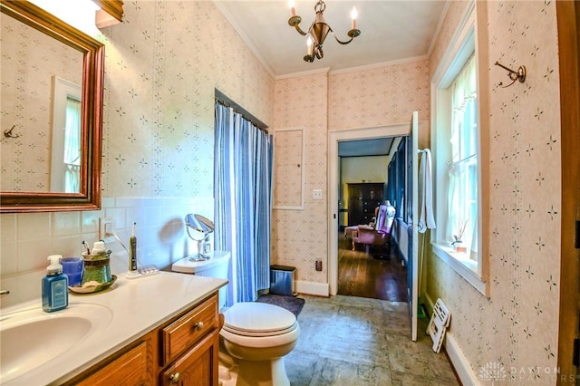 bathroom with an inviting chandelier, ornamental molding, wallpapered walls, and vanity