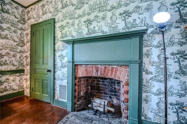 room details with baseboards, a brick fireplace, wallpapered walls, and wood finished floors
