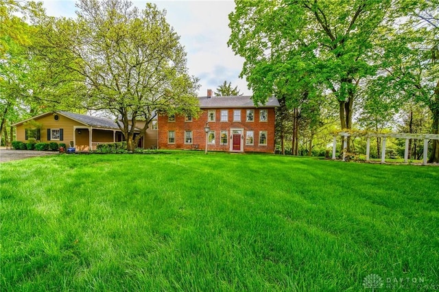 back of house with a yard and a chimney