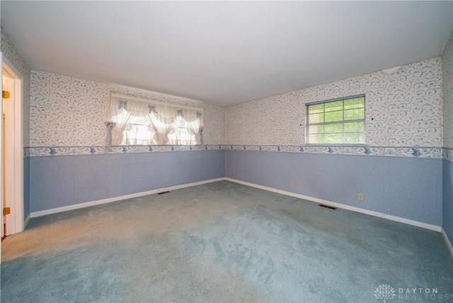 empty room featuring wallpapered walls, visible vents, and carpet
