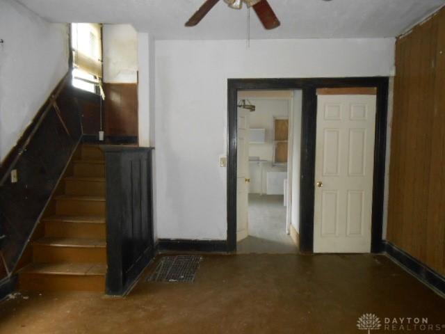 stairway featuring ceiling fan