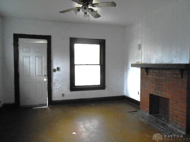 unfurnished living room with finished concrete floors, a ceiling fan, and a fireplace