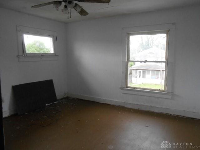 empty room with baseboards, a ceiling fan, and wood finished floors