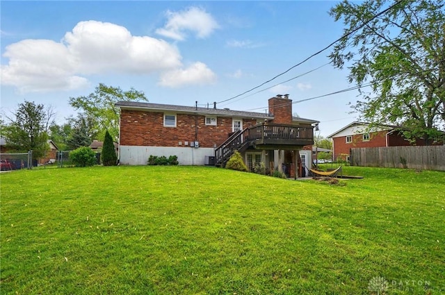 rear view of house featuring fence, a yard, stairway, and a deck