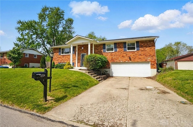 bi-level home with an attached garage, a front lawn, driveway, and brick siding
