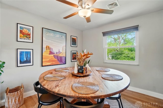 dining space featuring baseboards, ceiling fan, light wood-style flooring, and visible vents