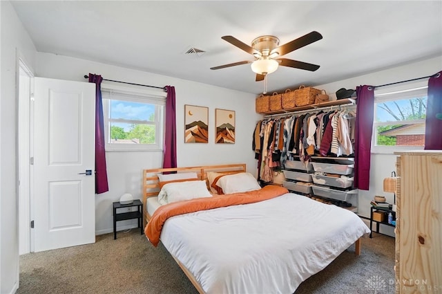 carpeted bedroom featuring visible vents and a ceiling fan
