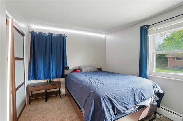 bedroom with carpet floors and a baseboard heating unit