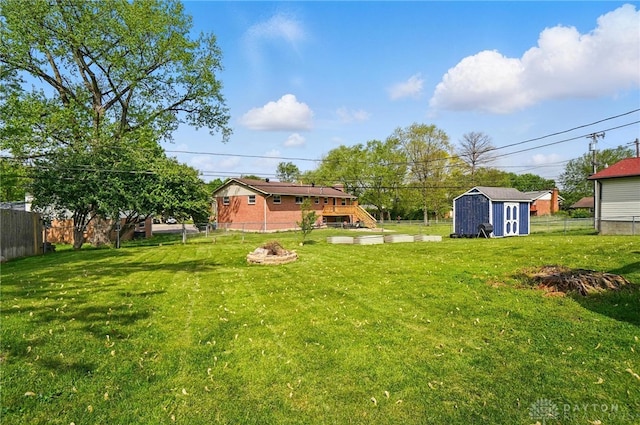 view of yard featuring a storage unit, a fenced backyard, and an outdoor structure