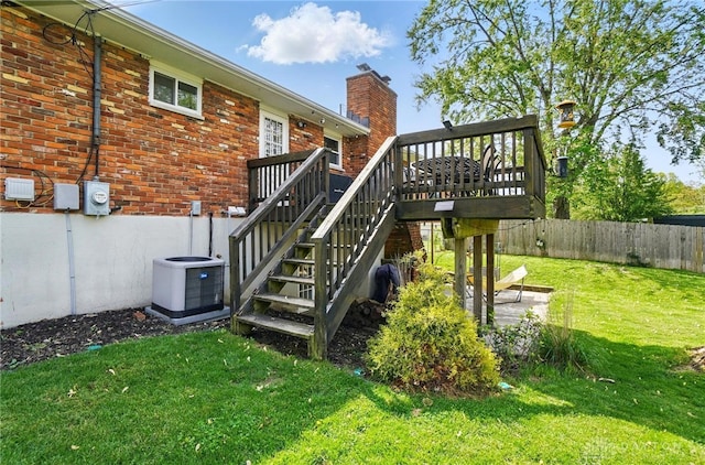 exterior space with a lawn, fence, central AC, and stairway