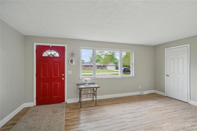 59 Janet Ave, Carlisle, OH 45005 - foyer featuring baseboards, a textured ceiling, wood finished floors, and visible vents